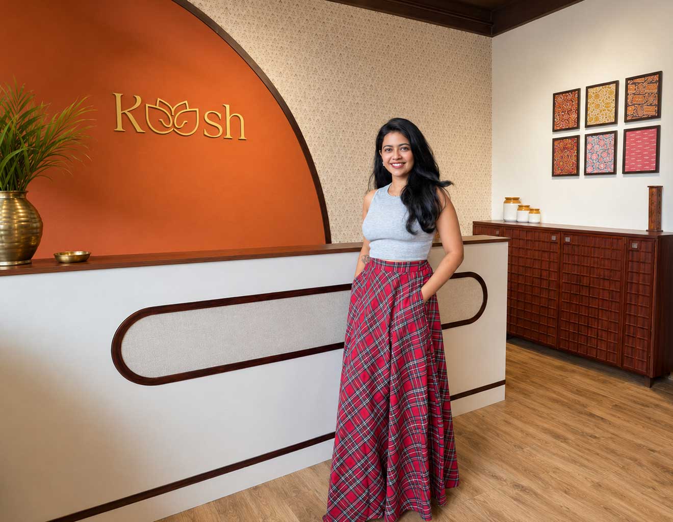Woman standing in a room with a 'Koosh' logo on an orange wall.