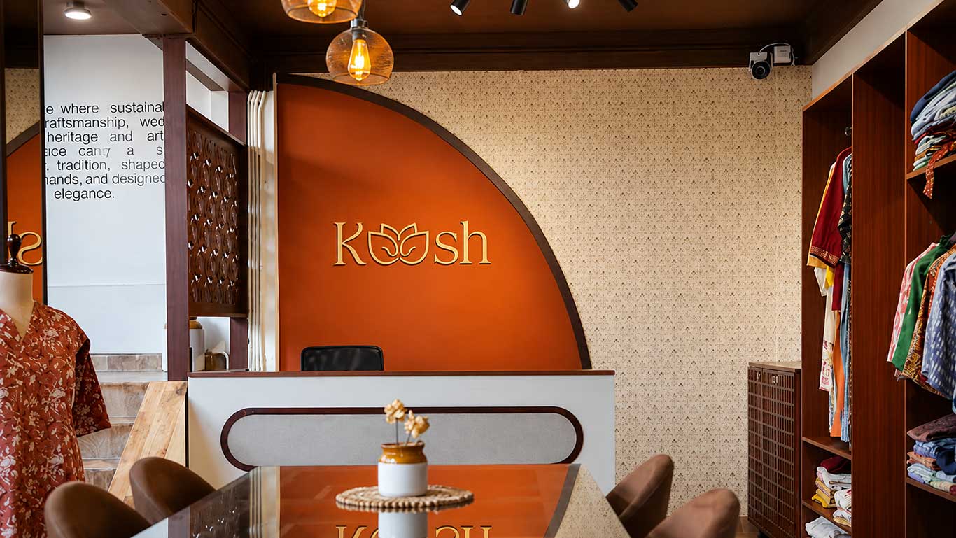 Interior of a store with 'Kosh' branding on an orange wall.