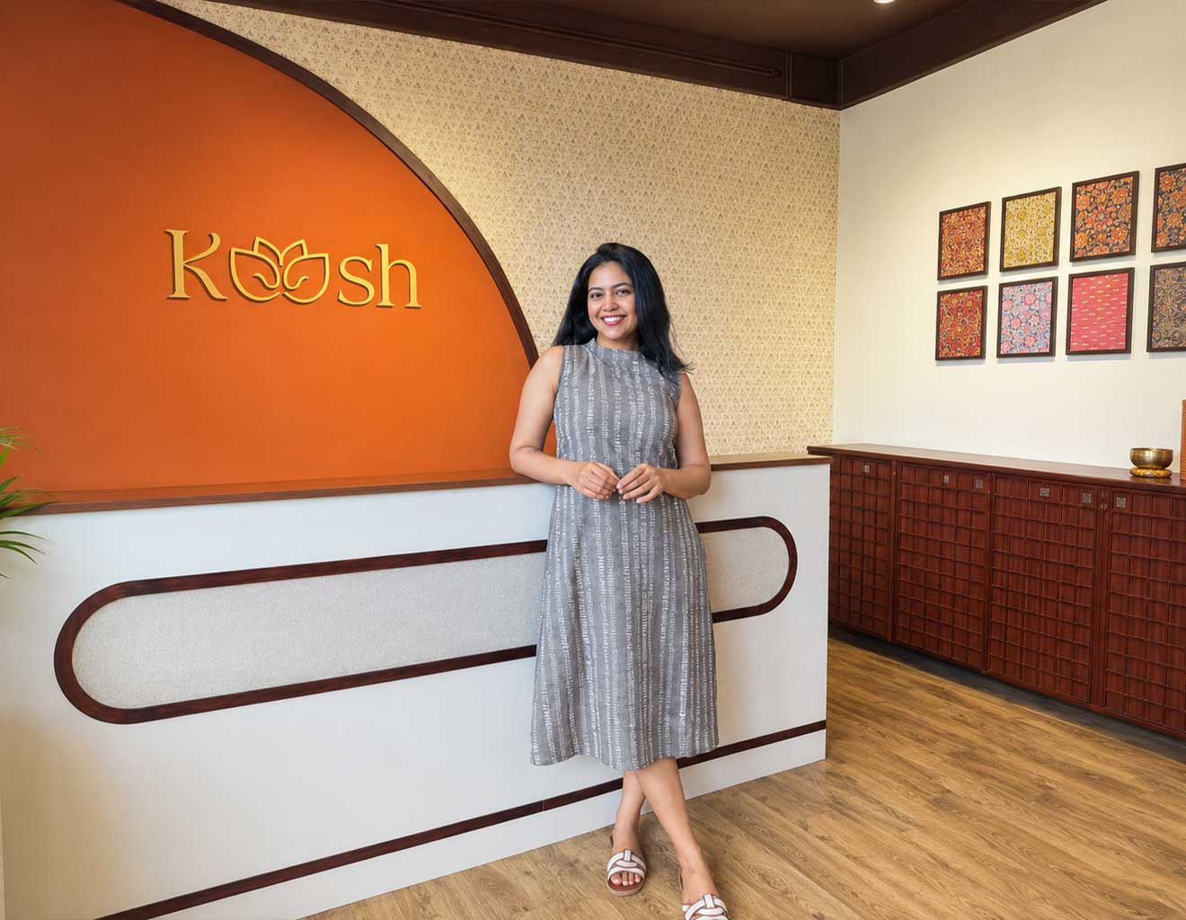 Woman standing in a modern interior setting with 'Koosh' branding.